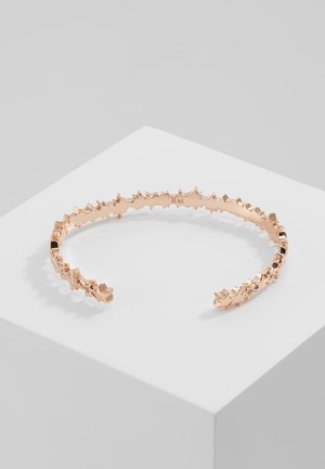 Rosegouden armband met onregelmatige, getextureerde spikes langs de buitenrand, aan de binnenkant gegraveerd met "RM".