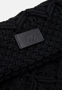 Černá pletená tkanina s texturovaným vzorem a obdélníkovou černou koženou etiketou s embosovaným nápisem "RL". Materiál se zdá být měkký a hustý.