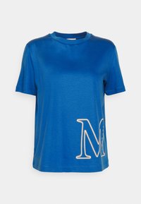 Camiseta de algodón azul con cuello redondo, mangas cortas y una gran "M" blanca bordada en el lado izquierdo. Textura suave.