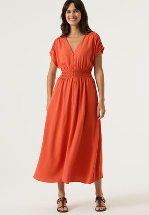 Oranje maxi-jurk met korte mouwen, diepe V-hals, elastische tailleband en knoopsluiting aan de voorkant. Soepele stof en ontspannen silhouet.