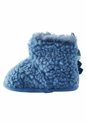 Chausson bleu doux pour tout-petit avec tissu texturé et duveteux et petites pointes en tissu au talon pour un look inspiré des dinosaures.