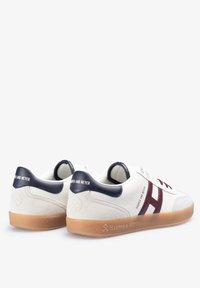 Zapatillas blancas con un cuello acolchado en azul marino y acentos en burdeos. Presentan un panel de ante texturizado y una suela de goma. Marcado en el talón.