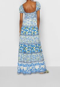 Maxi šaty s nabíranými rukávy, přiléhavým tělem s nařasením, květinovými vzory v modré a zelené barvě a zadním zipem.