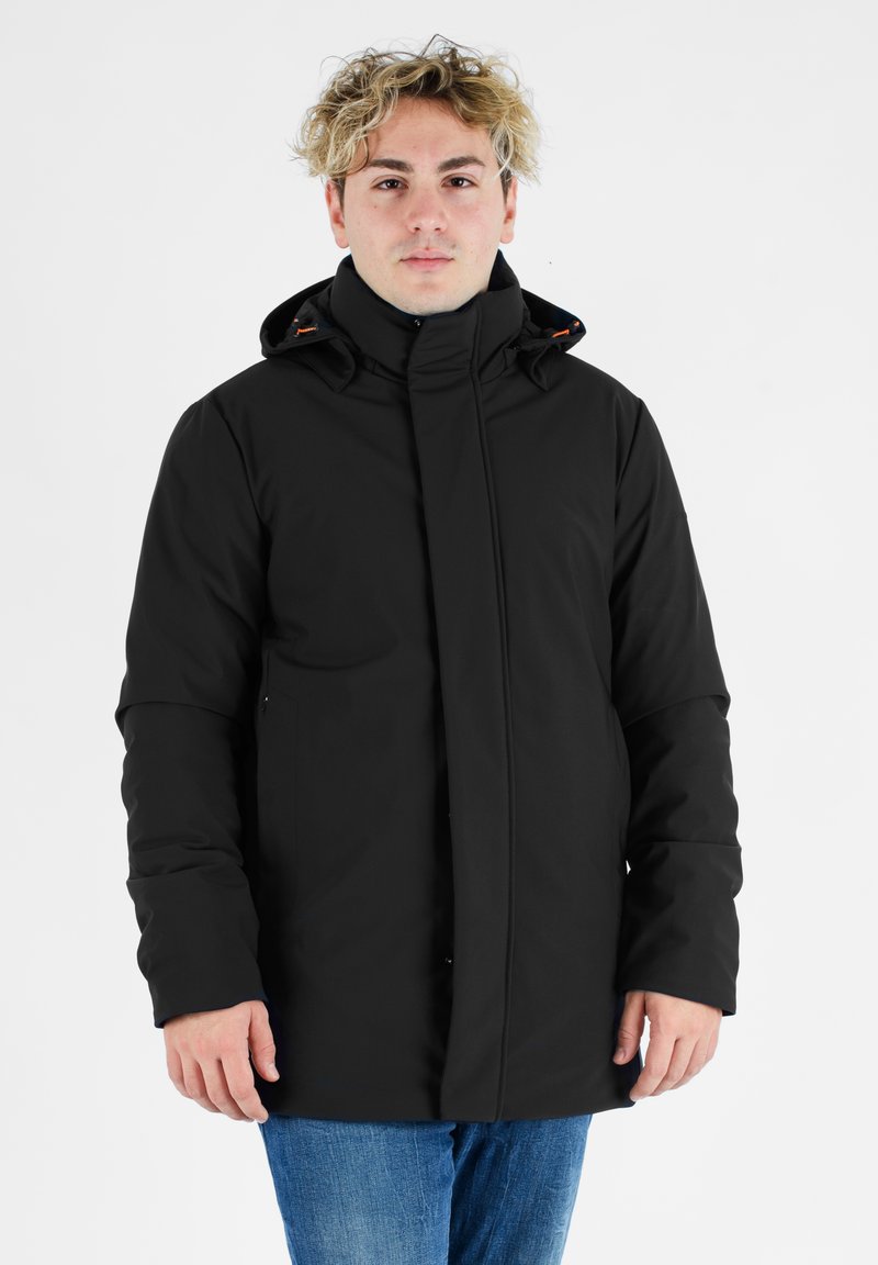 Giacca impermeabile nera con colletto alto, cappuccio e chiusura con cerniera. Presenta una texture liscia e sottili accenti arancioni vicino al cappuccio.