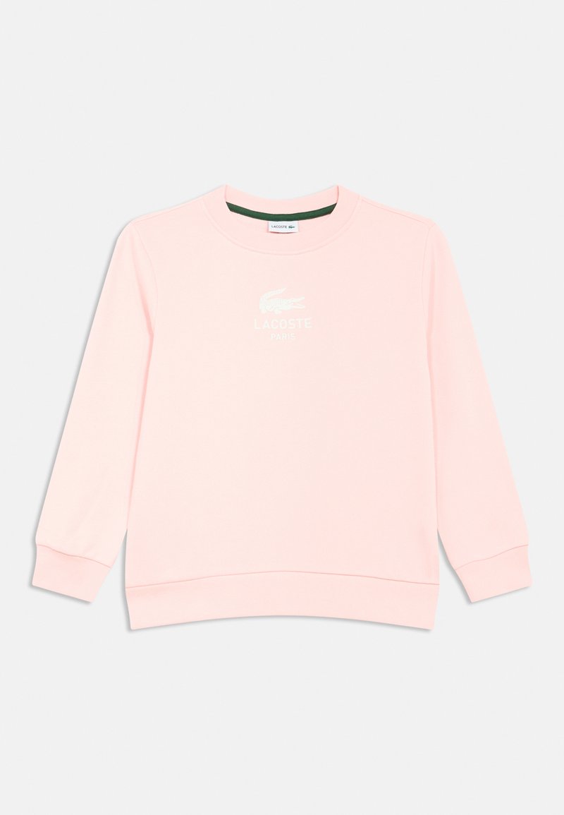Sweatshirt rosa claro feita de material macio, com gola redonda, mangas compridas, punhos canelados e o logótipo da Lacoste em branco na frente.