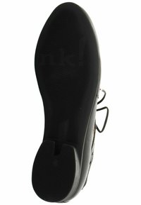 Semelle en caoutchouc noir avec des rainures texturées, présentant un design découpé et un logo en relief, offrant adhérence et durabilité.