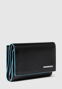 Cartera de cuero negro con una textura suave, que cuenta con ribete azul a lo largo de los bordes y una placa de logotipo metálica en el frente.