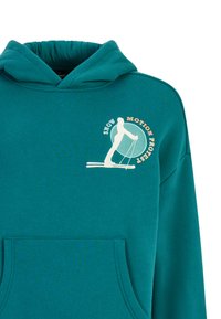 Tyrkysová mikina s kapucňou, ktorá má predné vrecko a grafiku lyžiara so slovami "SNOW MOTION PROTEST" v krémových a oranžových odtieňoch.