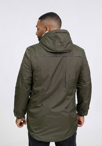 Veste à capuche vert olive avec une finition déperlant, dotée de manches longues, d'une fermeture éclair à l'avant et de poignets élastiques. Texture lisse, design mi-long.