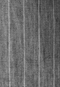 Tissu textile avec une base gris foncé et de fines rayures blanches verticales, mettant en valeur un tissage texturé et un motif cohérent tout au long.