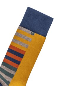 Farverig sok med en gul krop og mønstrede striber i nuancer af blå, grå, orange og grøn, samt en blå ribkant øverst.