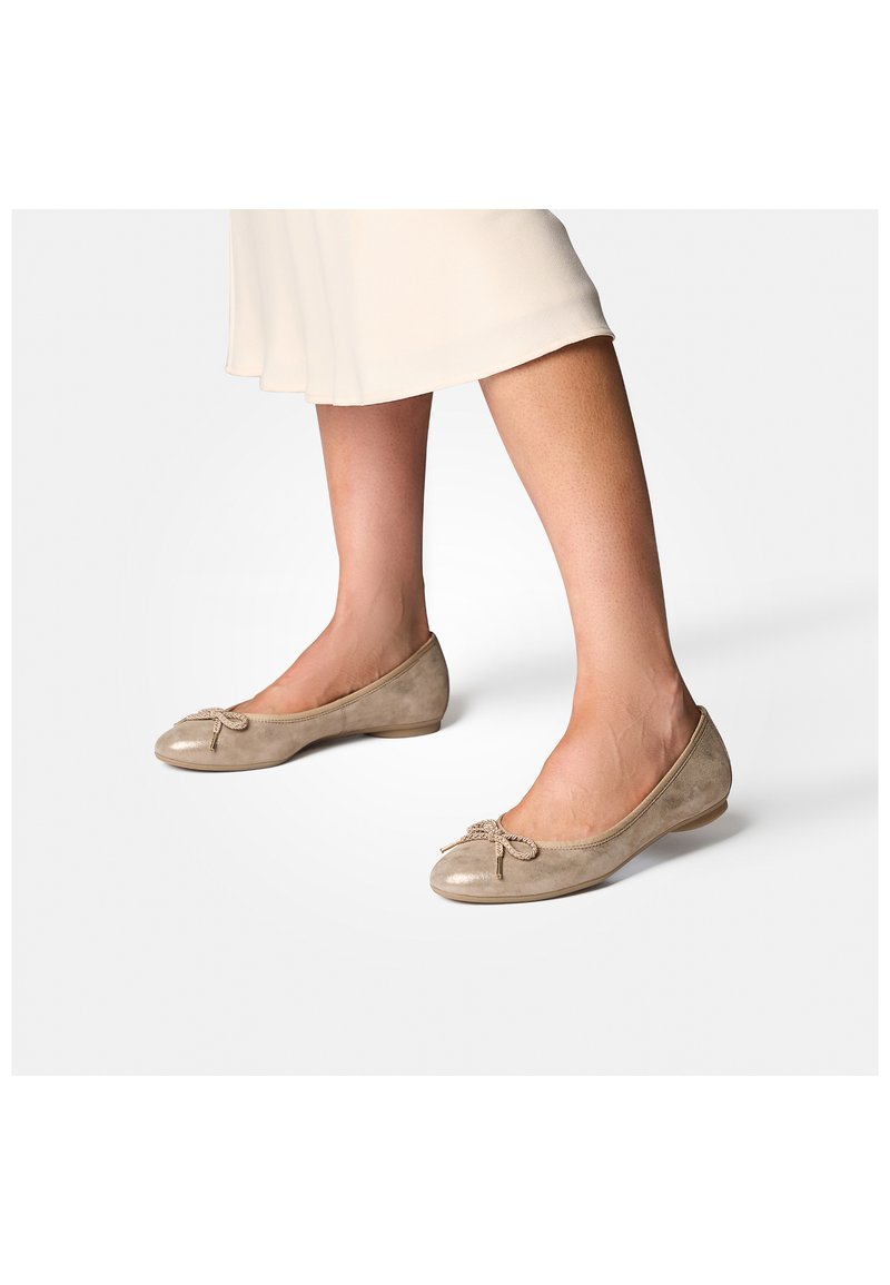 Ballerine in suede beige con punta tonda e dettaglio decorativo a fiocco davanti, montate su una suola in gomma bassa e flessibile.