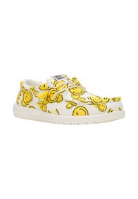 Witte schoenen met een herhalend geel smiley-gezichtpatroon, voorzien van witte veters en een gestructureerde rubberen zool, wat zorgt voor een casual uitstraling.