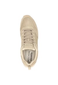 Beige sneaker met een geperforeerde bovenkant met textuur, platte veters en een logo op de tong. Heeft een luchtgekoelde memory foam binnenzool en een rubberen buitenzool.