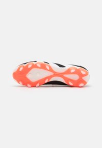 Sole di scarpa sportiva in bianco e nero con tacchetti rosa e bianchi, dotata di una superficie liscia e linee di design dinamiche.