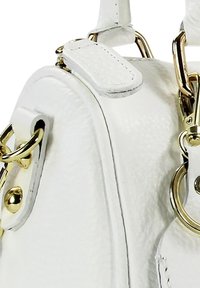 Witte leren handtas met een gestructureerd oppervlak, gouden metalen accenten en meerdere bevestigingspunten voor riemen.