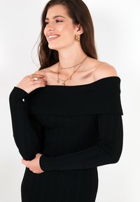 Musthave mustriba off-shoulder kleit pikkade varrukatega. Sile tekstuur, keha järgiv disain. Kulla ehted aktsentideks hõbedased kaelakeed ja kõrvarõngad.
