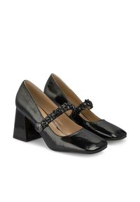 Zapatos de tacón bloque de charol negro con punta afilada y una correa decorativa de cuentas negras a través del empeine. Textura suave y brillante.