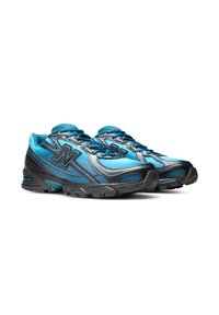 Двойка сини и черни атлетични маратонки с логото на New Balance, изгледани отпред от дясната страна на бял фон.