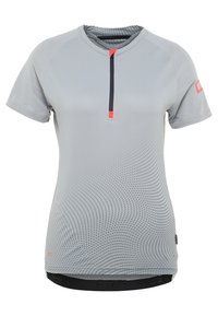 Camiseta atlética gris de manga corta que presenta una media cremallera, textura en puntos y acentos naranjas contrastantes en el cuello y las mangas.