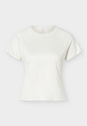 T-shirt blanc à manches courtes, col rond, coupe ajustée et coutures raglan sur un fond uni clair.