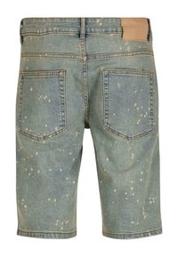 Traperice kratke, svijetloplave boje s izgužvanim završetkom, s svijetlijim pjegama, pet džepova i jednostavnim bež kožnim oznakom na stražnjem dijelu struka.