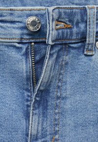 Jeans din denim de un albastru deschis prezintă un fermoar și un nasture argintii, cu o cusătură vizibilă și un design clasic cu cinci buzunare.