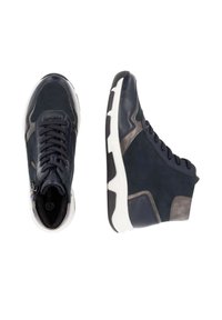 Baskets montantes bleu marine en cuir et daim, avec une semelle blanche, des accents texturés et des détails gris contrastants.