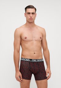 Boxer brief neri con motivi a foglia rossa, vita elastica con la scritta "ONLY&SONS" in bianco, realizzati in un tessuto liscio.