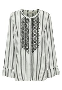 Blouse blanche à rayures noires verticales, panneau avant brodé en dentelle noire, col rond, poignets évasés et fermeture boutonnée.