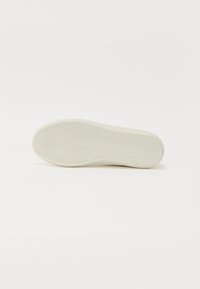 Balta sportinio batelio pado dalis su žuvies kaulo raštu, nukreipta į viršų ant paprasto balto fono.