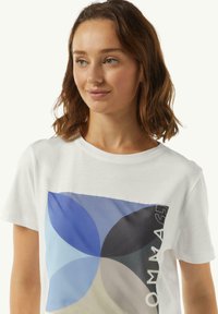 Biała bawełniana koszulka z dużą grafiką, na której znajdują się nakładające się niebieskie, szare i kremowe płatki. Zawiera tekst w nowoczesnej czcionce z boku.