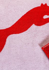 Tappeto da bagno rosso con una silhouette stilizzata di un cavallo. La texture è morbida e pelosa, e lo sfondo è di un rosa chiaro. Include un bordo rosso.