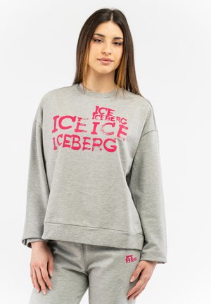 Gray sweatshirt with faded pink "ICEBERG" printed text, featuring a loose fit and ribbed cuffs. Paired with matching gray pants.