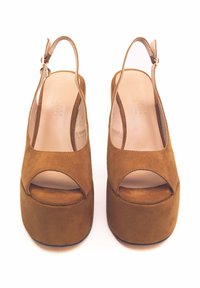 Sandali in suede marrone con design open toe, cinturino slingback e una suola interna liscia. Presentano un alto plateau e minimi dettagli in metallo.
