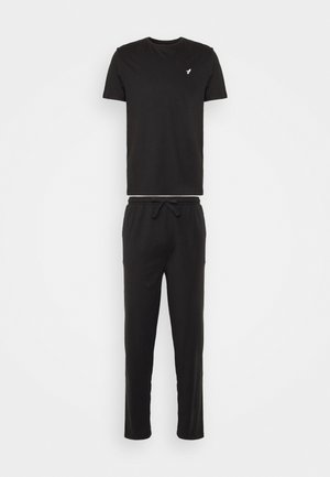 Black cotton t-shirt and matching pants, both with a relaxed fit. T-shirt has short sleeves and a small logo on the chest. Pants feature an elastic waistband.