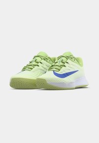 Hellgrüne Sportschuhe mit strukturierter Oberseite, blauem Nike-Swoosh und weißer Sohle. Verfügt über ein Schnürdesign und ein Gummiaußensohlenmuster.