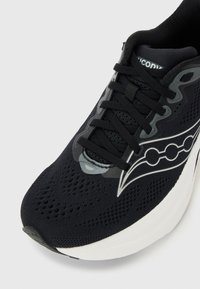 Αθλητικό παπούτσι από μαύρο δίχτυ με μαύρα κορδόνια, λευκή σόλα και αντανακλαστικά ασημένια σχέδια στο πλάι κ αι στο λογότυπο στη γλώσσα.