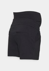 Calções pretos com uma cintura ajustada, feitos de tecido suave. Apresenta dois bolsos frontais e um design minimalista sem adornos.