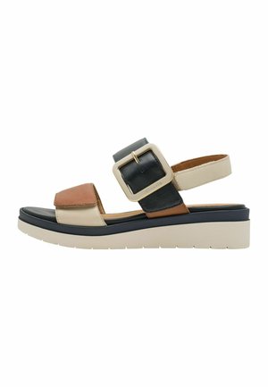 Sandales compensées en cuir marron, noir et beige, avec une grande boucle carrée et une semelle plateforme blanche texturée.