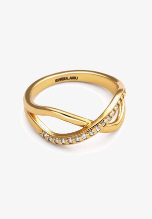 Pierścionek z metalowego materiału w złotym odcieniu o skręconym wzorze, z rzędem małych przezroczystych kryształów po jednej stronie. Gładka faktura, polerowane wykończenie.