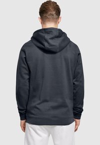 Mörkgrå hoodie med dragsnodd i huvan, ribbade ärmslut och nederkant. Har en slät textur och en enkel, minimalistisk design.
