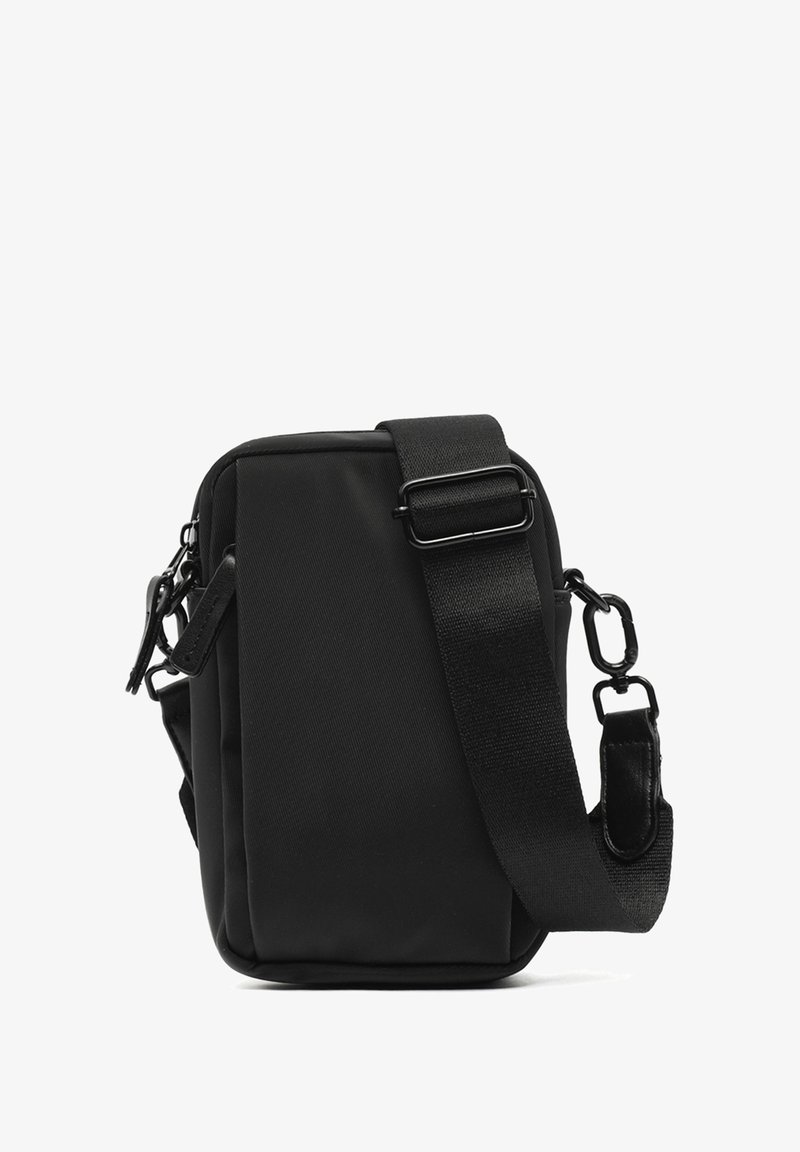 Compact black crossbody bag made of durable fabric. Features a textured surface, adjustable strap, and zippered compartments on the side.