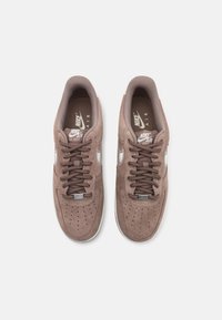 Bruna mockaskinn Nike Air Force 1 sneakers med platta snören, perforerad tånända, vit swoosh-logotyp och en vadderad krage för komfort.