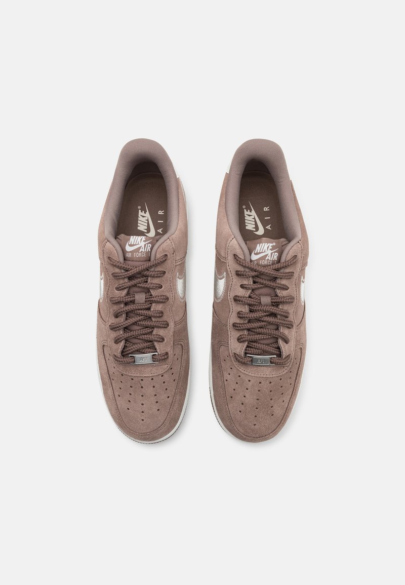 Baskets Nike Air Force 1 en daim marron avec des lacets plats, une boîte à orteils perforée, un logo swoosh blanc et un col rembourré pour le confort.