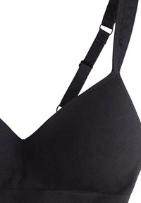 Mustat bralette-vartalonmuotoilut V-aukolla, valmistettu pehmeästä kankaasta. Varustettu säädettävillä olkaimilla ja saumatonta viimeistelyä mukavuutta varten.