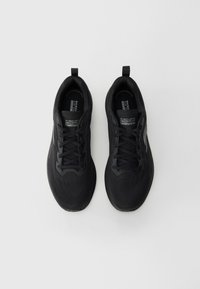 Baskets de sport noires avec une tige en mesh respirant, un design à lacets et des languettes à l'arrière pour un enfilage facile. Semelle légère et rembourrée.
