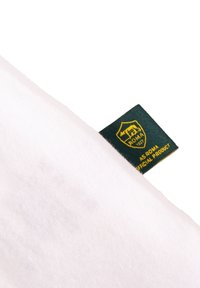 Witte katoenen t-shirt met een groen geweven label met gele tekst en een schildlogo dat "AS Roma Official Product" zegt.