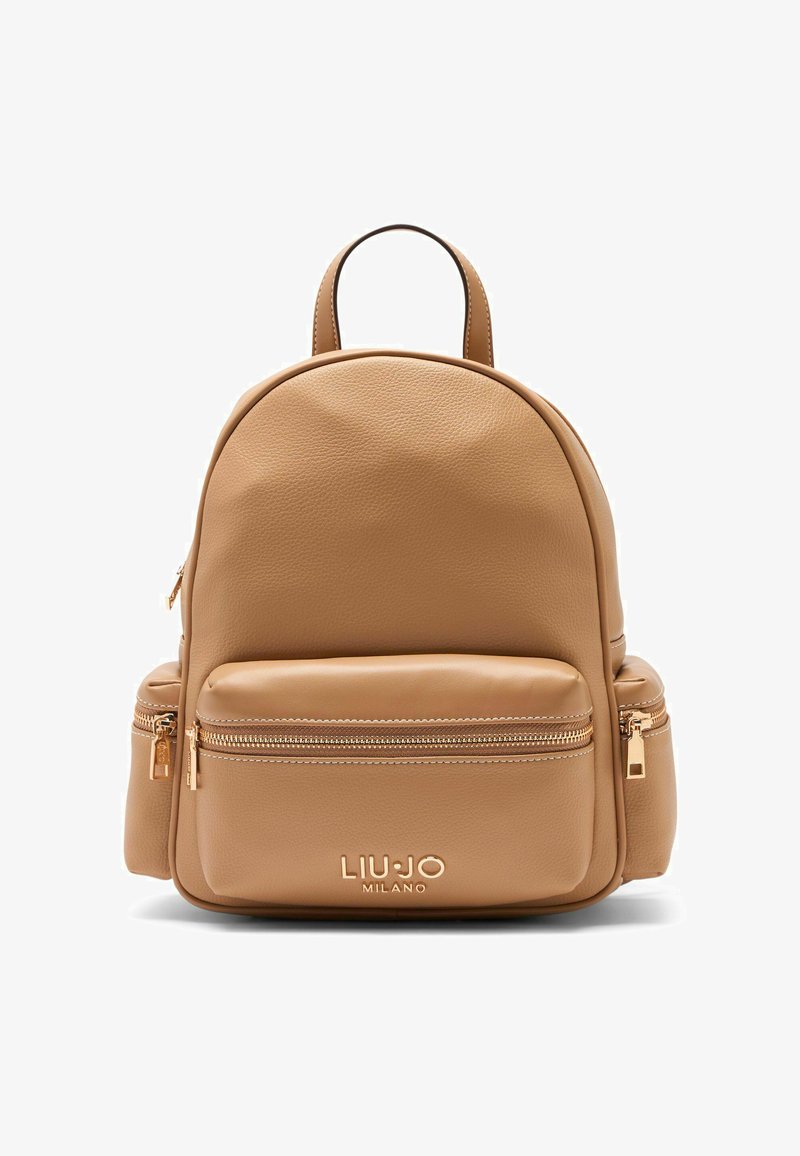 Mochila de cuero color coñac con forma redondeada, que cuenta con un bolsillo frontal con cremallera y detalles en herrajes dorados. Logotipo en relieve en la parte inferior.