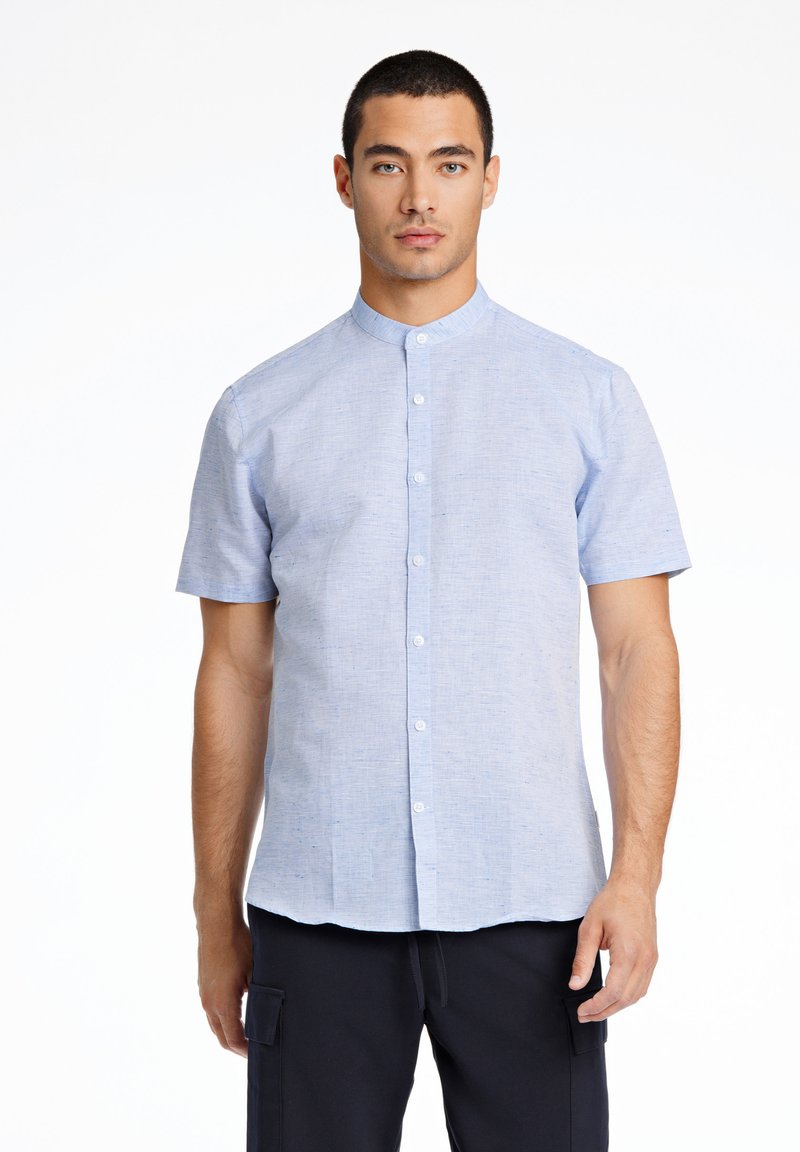 Camicia azzurro chiaro a maniche corte con colletto a fasce, realizzata in tessuto caratterizzato, dotata di chiusura frontale con bottoni e orlo leggermente curvo.